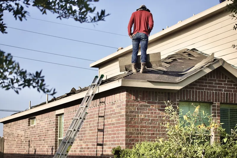 Professional roofer working on a residential roof in Kinna